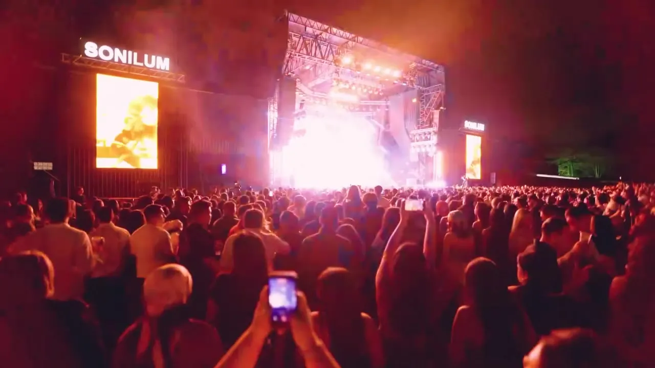 Público frente al escenario iluminado durante el concierto de Beéle
